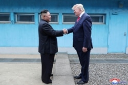 FILE - U.S. President Donald Trump shakes hands with North Korean leader Kim Jong Un as they meet at the demilitarized zone separating the two Koreas, in Panmunjom, South Korea, June 30, 2019. (KCNA via Reuters)