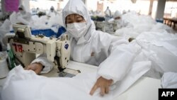 Workers sew hazardous material suits to be used in the COVID-19 outbreak at the Zhejiang Ugly Duck Industry garment factory in Wenzhou, China. (Photo by NOEL CELIS / AFP)