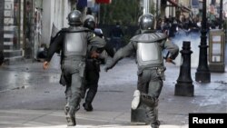 Tunisian riot police run towards protesters during a demonstration in Tunis, February 7, 2013. 