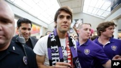 Bintang sepakbola Brazil, Kaka, dikawal petugas keamanan dan polisi tiba di bandar udara internasional Orlando, 2014.