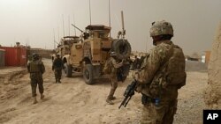 US soldiers keep watch at the entrance of a military base near Alkozai village following the shooting of Afghan civilians allegedly committed by a rogue US soldier in Panjwayi. NATO's International Security Assistance Force said it had arrested a soldier 