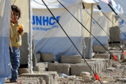 A Syrian displaced girl, who fled violence after the Turkish offensive in Syria, looks on at Bardarash refugee camp on the outskirts of Dohuk, Iraq, Oct. 22, 2019.