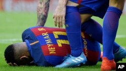 Neymar du FC Barcelone, touché par un projectile, se tord des douleurs sur la pelouse, lors du match de la Liga espagnole de football entre Valence et le FC Barcelone au stade Mestalla à Valence, en Espagne, 22 octobre 2016.