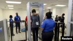 FILE - Autistic boy, Jeffery Jr. Simonton, walks through metal detector while a Transportation Security Administration (TSA) agent looks on.