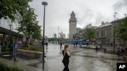 Seorang perempuan mengenakan masker berjalan di sebuah jalan di Moskow, Rusia, Kamis, 10 Juni 2021. 