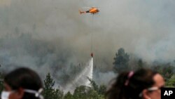 Firefighters drop water on a forest fire in Portezuelo, Chile, Jan. 29, 2017.