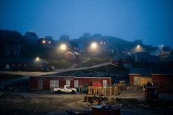 FILE - Early morning fog shrouds homes in Kulusuk, Greenland, Aug. 15, 2019. The Arctic is taking on new geopolitical and economic importance, and not just the United States hopes to stake a claim, with Russia, China and others all wanting in.