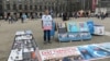 FILE - Abdurehim Gheni stands in demonstration with pictures of his relatives and other disappeared Uighurs, at Dam Square in Amsterdam in July. (Photo courtesy: Abdurehim Gheni)