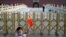 A child holds up a Chinese national flag as he poses for a photo in front of Tiananmen Gate in Beijing, June 4, 2014.