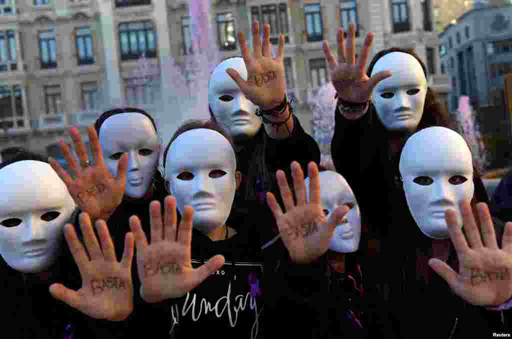 Gender studies students wearing masks pose with the word &quot;Enough&quot; written on their hands during a performance to commemorate victims of gender violence, during the U.N. International Day for the Elimination of Violence against Women, in Oviedo, Spain, Nov. 25, 2016.