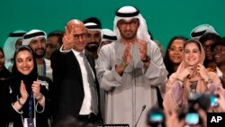U.N. Climate Chief Simon Stiell, from left, COP28 President Sultan al-Jaber and Hana Al-Hashimi, chief COP28 negotiator for the United Arab Emirates, pose at the end of the COP28 U.N. Climate Summit, on Dec. 13, 2023, in Dubai, United Arab Emirates. (AP Photo/Kamran Jebreili)