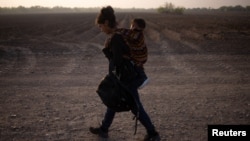 Mayra, a 17-year-old asylum-seeking mother from Guatemala, carries her 13-month-old son Marvin after they crossed the Rio Grande river into the United States from Mexico on a raft in Penitas, Texas, U.S., March 17, 2021. (REUTERS/Adrees Latif)