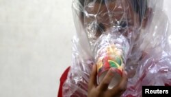 A boy tries on an improvised gas mask in Idlib, Syria, Sept. 3, 2018. The U.S. special adviser for Syria said there is evidence that chemical weapons are being prepared by Syrian forces around Idlib.