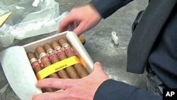 A US customs agent unwraps a box of illegal Cuban cigars that will be destroyed, Dec 2010