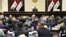 FILE - Iraqi Prime Minister Haider al-Abadi, center, attends a session of the Iraqi Parliament, in Baghdad, Iraq, Sept. 27, 2017. Iraq's Kurdish lawmakers are reportedly ending to their boycott of the national parliament.