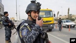 Iraqi federal policemen stand guard at a checkpoint in Basra Jan. 2, 2014. The Iraqi government has tightened security measures after security forces reportedly arrested al-Mukhtar Army commander, Wathiq al-Batat.