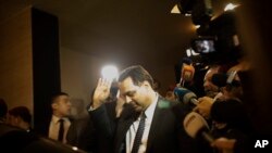 Newly-assigned Lebanese Prime Minister, Hassan Diab, gestures to journalists after arriving to his home following his meeting with Lebanese President Michel Aoun in Beirut, Lebanon, Dec. 19, 2019.