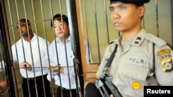 FILE - Australian death row prisoners Andrew Chan, center, and Myuran Sukumaran, left, are seen in a holding cell waiting to attend a review hearing in the District Court of Denpasar on the Indonesian island of Bali, October 8, 2010.