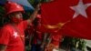 Pendukung partai Liga Nasional untuk Demokrasi (NLD) mengibarkan bendera Myamnar di Yangon pada 8 September 2020. Myanmar melewatkan KTT ASEAN setelah jenderal pemimpin dilarang menghadiri pertemuan itu. (Foto: AFP/Ye Aung Thu)