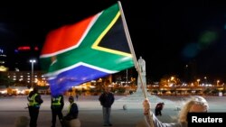 A girl holds a South African national flag as people mourn the death of former President Nelson Mandela outside Cape Town City Hall, where Mandela made his first speech after his release from his 27-year incarceration, Dec. 6, 2013. 