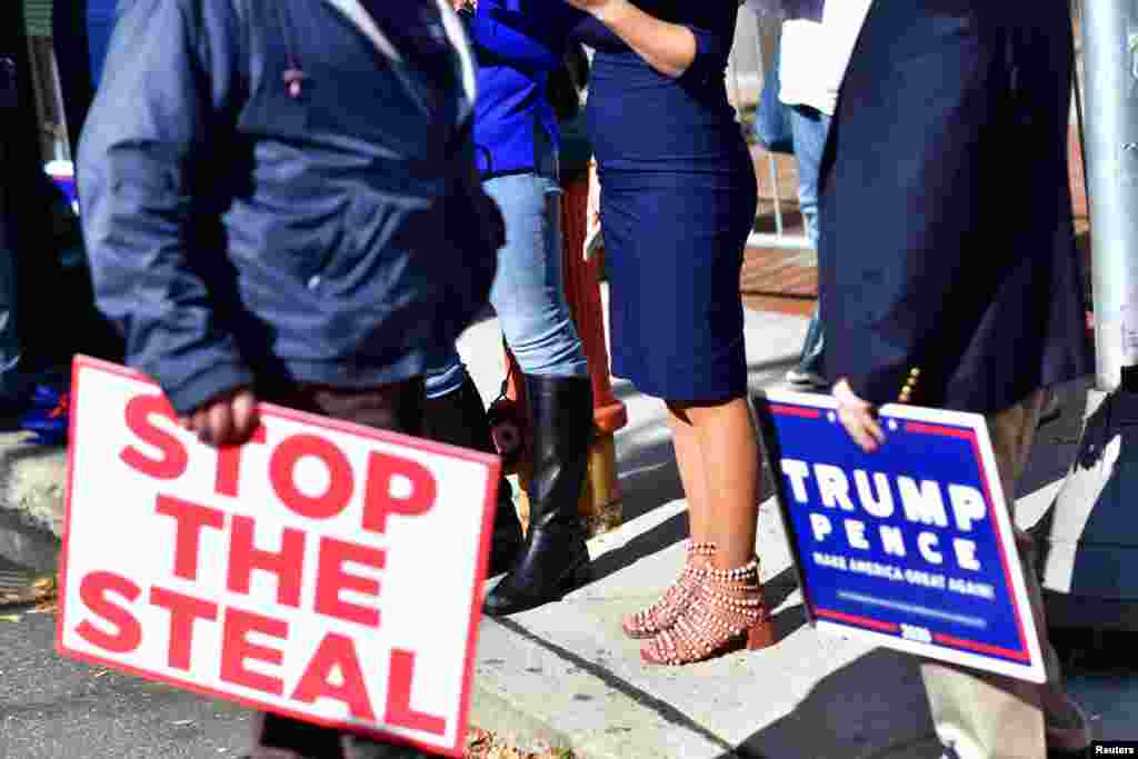 Trump supporters carry a &quot;Stop the Steal&quot; and campaign sign after Democratic presidential nominee Joe Biden overtook President Donald Trump in the Pennsylvania general election vote count, in Philadelphia, Pennsylvania, Nov. 6, 2020.