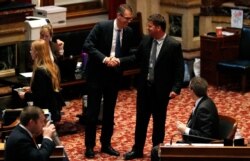 FILE - Sen. Randy Feenstra, R-Hull, left, talks with Sen. Rick Bertrand, R-Sioux City, following debate on the tax bill in the Iowa Senate, May 5, 2018, at the Statehouse in Des Moines.