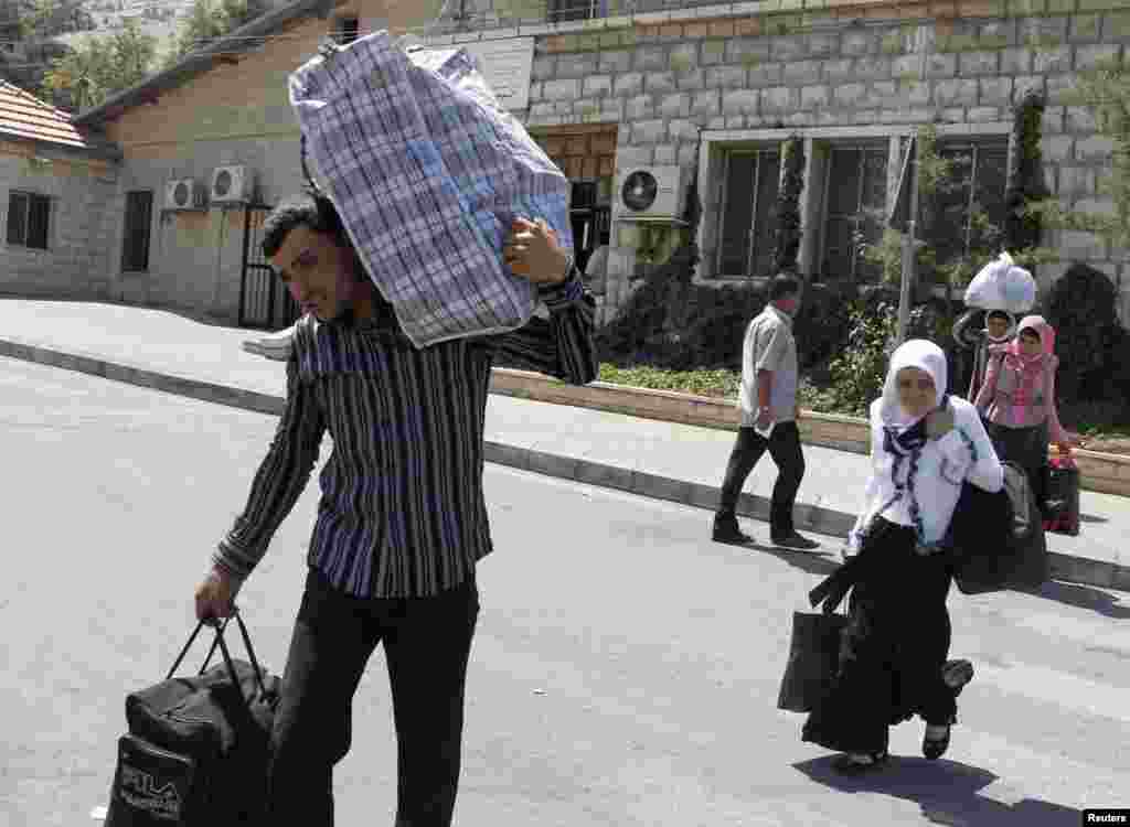 Suriyalik qochqinlar Livan-Suriya chegarasidan o&#39;tmoqda, 20-iyul, 2012-yil.