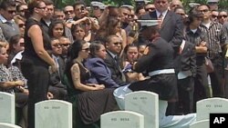 A marine presents the widow with a folded American flag.