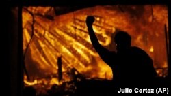 Demonstranti ispred policijske stanice u Mineapolisu koja je u plamenu