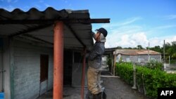 A man secures the roof of his house ahead of the arrival of then-Tropical Storm Rafael in Guanimar, Artemisa province, Cuba on Nov. 5, 2024.