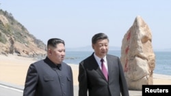 លោក​ប្រធានាធិបតី​ ស៊ី ជីនពីង ជួប​ជាមួយ​មេដឹកនាំ Kim Jong Un កូរ៉េ​ខាង​ជើង​នៅ​ក្នុង​ក្រុង Dalian ខេត្ត Liaoning ប្រទេស​ចិន នៅ​ក្នុង​រូបភាព​ដែល​ចេញ​ផ្សាយ​ដោយ​សារព័ត៌មាន Xinhua កាលពី​ថ្ងៃទី៨ ខែឧសភា ឆ្នាំ២០១៨។