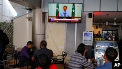 Warga Maladewa menyaksikan siaran televisi yang menayangkan pernyataan Presiden Yameen Abdul Gayoom, di sebuah kafe di Male, 24 September 2018.