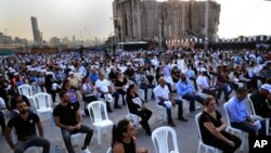 Para kerabat para korban yang ewas dalam ledakan hebat tahun lalu di pelabuhan Beirut, memegang foto korban dalam peringatan satu tahun tragedi itu, di pelabuhan Beirut, Lebanon, Rabu, 4 Agustus 2021. 