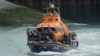 Un grupo de presuntos migrantes es llevado a Dover a bordo de un bote de las autoridades, en Kent, Inglaterra, el 4 de julio de 2021.
