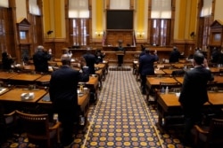 Members of Georgia's Electoral College are sworn in before casting their votes at the state Capitol, Dec. 14, 2020, in Atlanta.