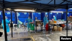 Para petugas medis yang mengenakan hazmat merawat para pasien di tenda darurat di luar sebuah rumah sakit di Hong Kong, pada 19 Februari 2022. (Foto: Reuters/Aleksander Solum)