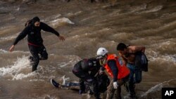 Paramedics and demostrators attend a youth who fell into the Mapocho river from a bridge during a police charge on protesters in Santiago, Chile, Oct. 2, 2020.