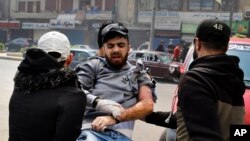 Anti-government protesters carry their friend who was wounded by a rubber bullet during clashes with Lebanese army soldiers, in the northern city of Tripoli, Lebanon, April 28, 2020. 