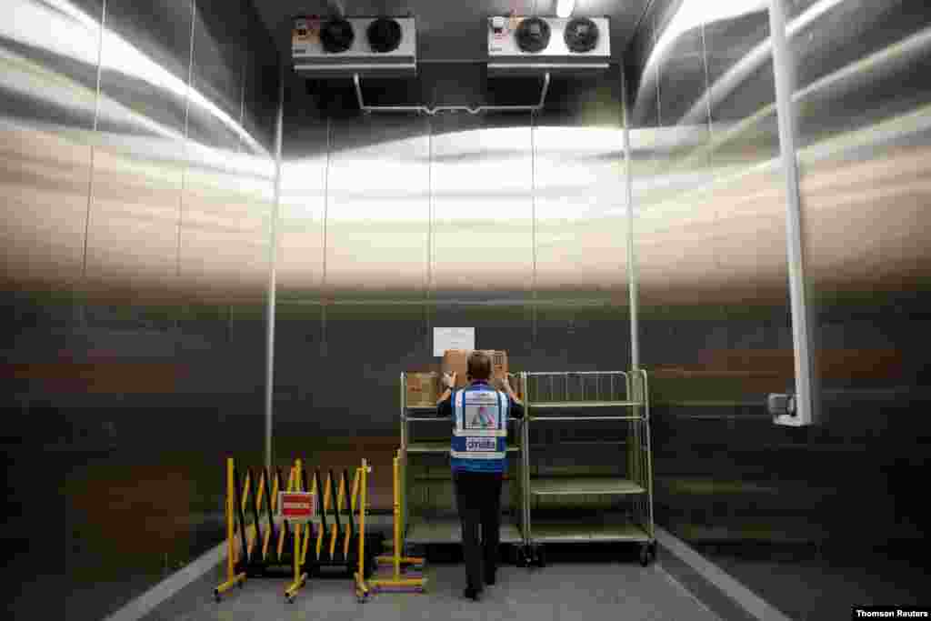 온도 조절이 가능한 싱가포르 디나타사의 냉동 저장소에서 직원이 신종 코로나바이러스 백신이 담긴 상자를 옮길 준비를 하고 있다. 