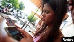 រូបឯកសារ៖ កញ្ញា ធី សុវណ្ណថា និងមិត្តភ័ក្តិប្រើ​ទូរស័ព្ទ​ចល័ត និង​បណ្តាញ​សង្គម នៅក្នុង​ហាង​កាហ្វេ​មួយ​នៅ​រាជធានី​ភ្នំពេញ កាលពី​ថ្ងៃទី១១ ខែធ្នូ ឆ្នាំ២០១៤។