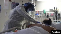 FILE - A medical staff member treats a patient suffering from the coronavirus disease (COVID-19) in the Intensive Care Unit (ICU), at Scripps Mercy Hospital in Chula Vista, California, U.S., May 12, 2020. (REUTERS/Lucy Nicholson/File Photo)