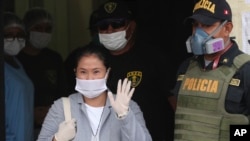 Wearing a mask against the spread of thew new coronavirus, former Peruvian presidential candidate Keiko Fujimori waves reporters as she is released from prison in Lima, Peru, May 4, 2020. 