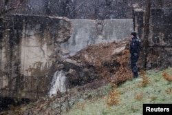 A police officer patrols near the damaged canal in Varage, near Zubin Potok, Kosovo, Nov. 30, 2024.