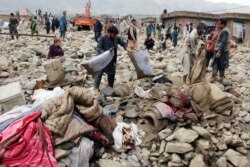 Afghan men search for their belongings after floods in Charikar, capital of Parwan province, Afghanistan, Aug. 26, 2020.