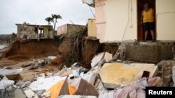 Yamary Morales looks at the damage at a neighbor's house after the area was hit by Hurricane Maria in Yabucoa, Puerto Rico Sept. 22, 2017. 