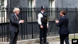 보리스 존슨 영국 총리가 18일 런던 다우닝가(Downing Street) 총리관저에서 에마뉘엘 마크롱 프랑스 대통령을 맞이했다. 두정상은 2차 세계 대전 중 프랑스의 샤를 드골 장군이 영국의 BBC 라디오를 통해 자국민들에게 독일 나치 항전을 촉구한지 80주년을 맞아 만남을 갔고 기념했다.