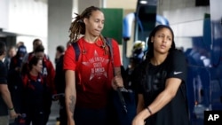 FILE - US women's basketball players Brittney Griner, left, and Maya Moore board a bus at the airport after arriving at the 2016 Summer Olympics in Rio de Janeiro, Brazil, Aug. 3, 2016.