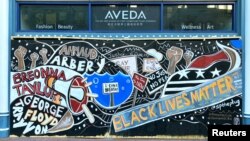 One of the protest murals adorns the plywood that boards exterior windows of a business, following the death of George Floyd in Minneapolis police custody, in downtown Washington, DC, June 14, 2020. (REUTERS/Katanga Johnson)
