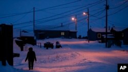 FILE - A woman walks in Toksook Bay, Alaska, a mostly Yup'ik village on the edge of the Bering Sea, Jan. 20, 2020. A judge ruled in favor of tribal nations in a bid to keep Alaska Native corporations from getting part of $8 billion in COVID relief funding