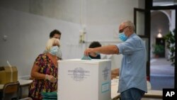 A man casts his ballot at a polling station, in Rome, Sept. 20, 2020.